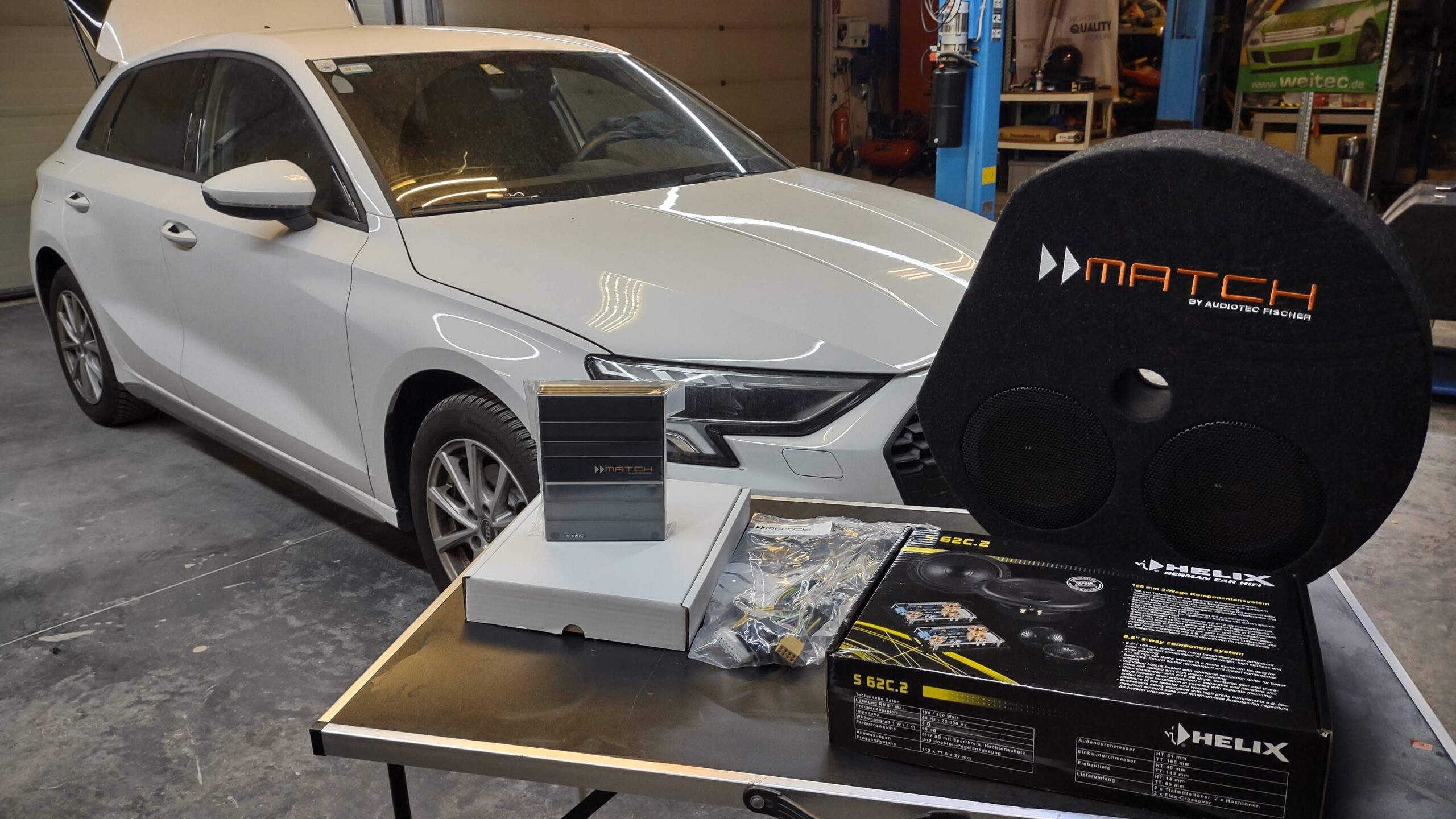 a car with speakers and boxes on a table